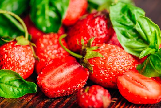 Whole and Sliced Strawberries and Basil Leaves Background.