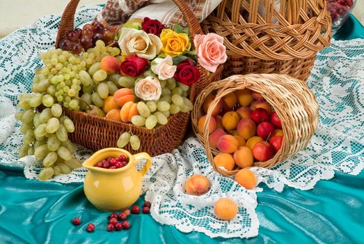 Wicker basket and different fruits on a studio background