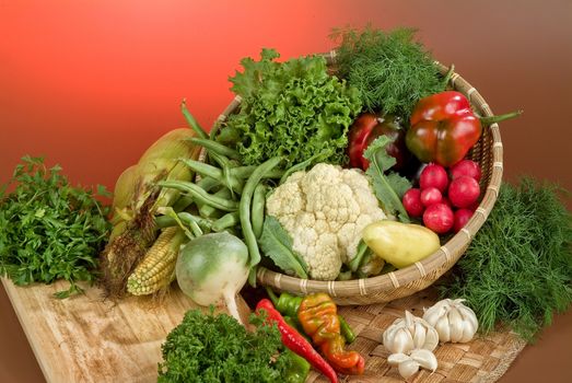 Wicker basket and vegetables on a studio background