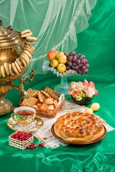 Russian traditional water boiler, fruits and bread on a studio background