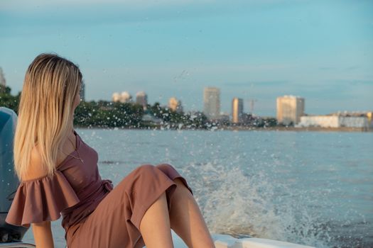 The guy jumps into the water from the boat. A beautiful girl is watching him