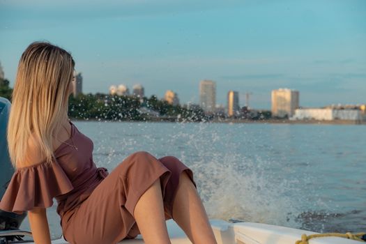 The guy jumps into the water from the boat. A beautiful girl is watching him