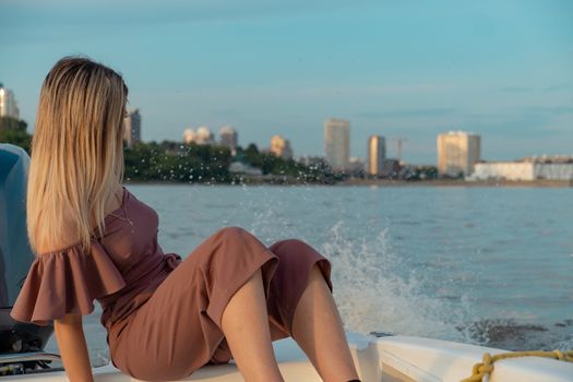 The guy jumps into the water from the boat. A beautiful girl is watching him