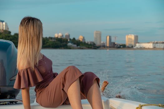 The guy jumps into the water from the boat. A beautiful girl is watching him