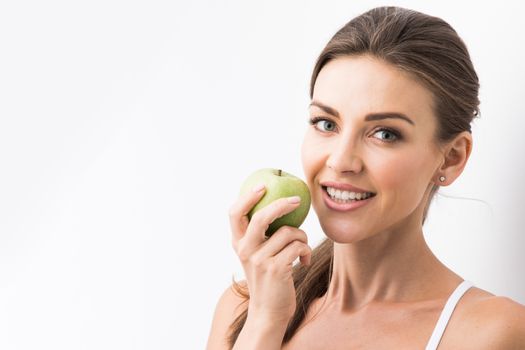 Beautiful young nude woman with green apple close up on white background