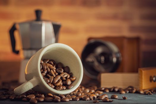 Coffee bean in the white cup and coffee grinder on wooden table. Concept breakfast or coffee time in morning.