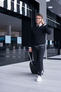 Portrait of a smiling travel man walking and talking on mobile phone