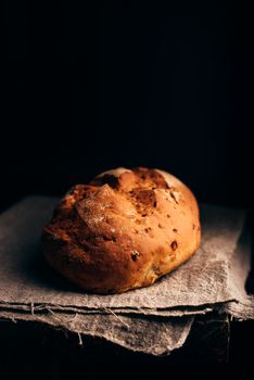 Loaf of Bread on Grey Cloth. Dark Background and Copy Space on the Top.