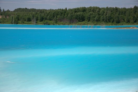 Beautiful blue lake with shores overgrown with coniferous forest.