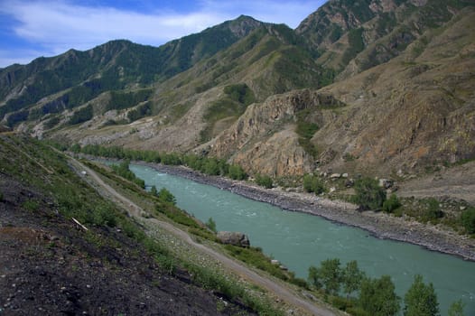 An unusually beautiful turquoise river flows at the foot of the mountains. Katun, Altai, Siberia, Roosia.