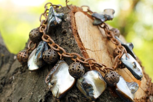 the Hand made copper bracelet with nacre on the wooden background