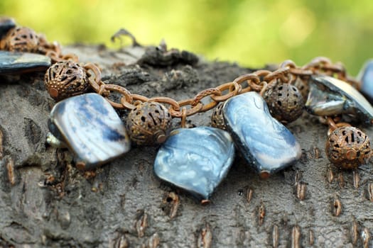 a Hand made copper bracelet with nacre on the wooden background