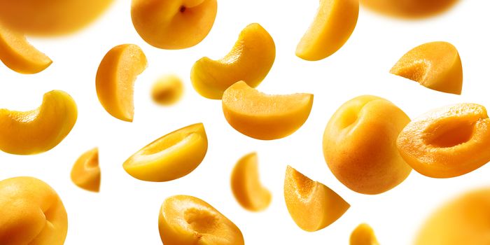 Apricots levitate on a white background. Ripe fruit in flight.