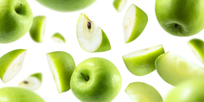 A group of green apples levitating on a white background.