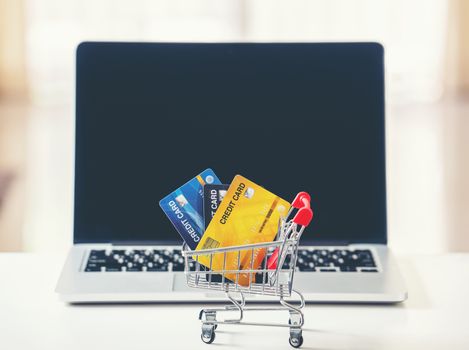 online shopping concept, Shopping cart and credit card with laptop on the desk