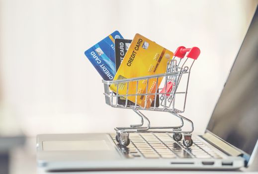 online shopping concept, Shopping cart and credit card with laptop on the desk