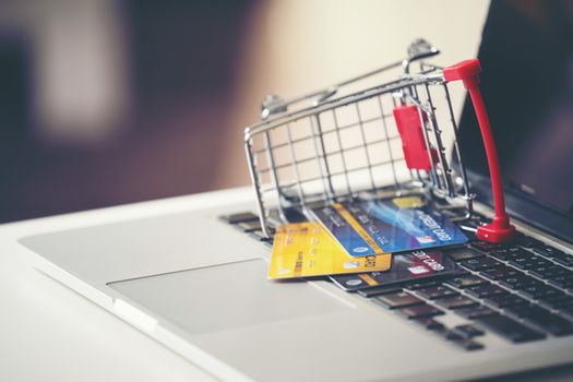 online shopping concept, Shopping cart and credit card with laptop on the desk