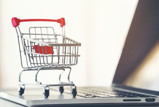 shopping cart with laptop on the desk, online shopping concept