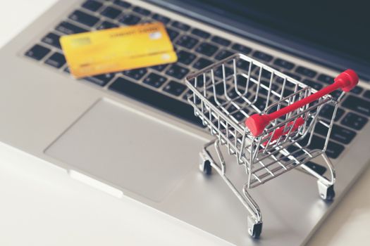 online shopping concept, Shopping cart and credit card with laptop on the desk