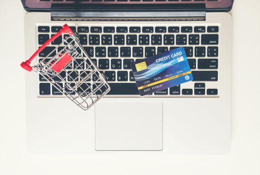 online shopping concept, Shopping cart and credit card with laptop on the desk