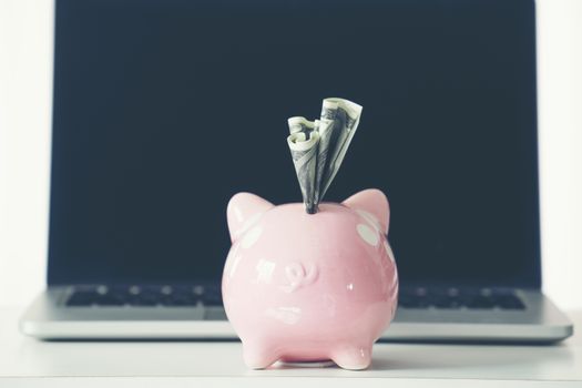 piggy bank with laptop on the desk, online shopping concept