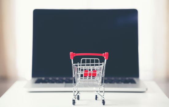 shopping cart with laptop on the desk, online shopping concept