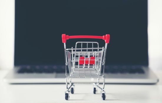 shopping cart with laptop on the desk, online shopping concept