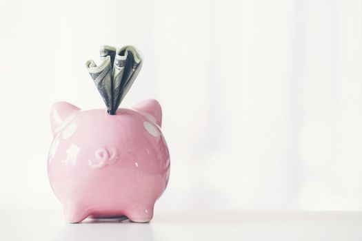 pink color piggy bank on white table, saving concept