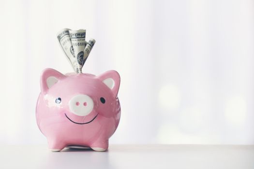 pink color piggy bank on white table, saving concept