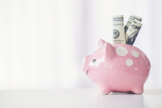 pink color piggy bank on white table, saving concept