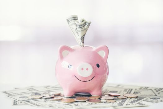 pink color piggy bank on white table, saving concept