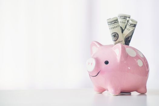 pink color piggy bank on white table, saving concept