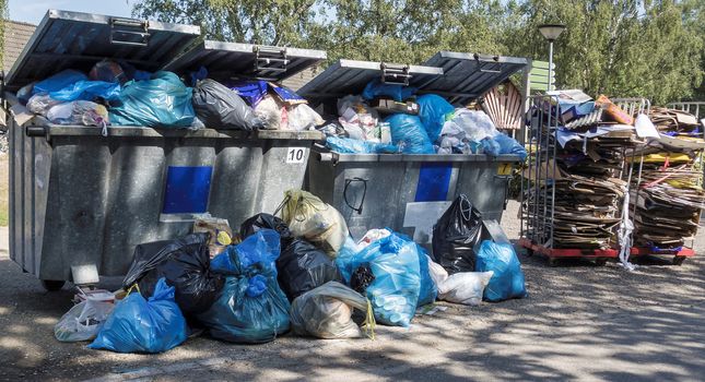 garbage containers that are full of garbage and junk because the collection service strikes and the bins do not empty