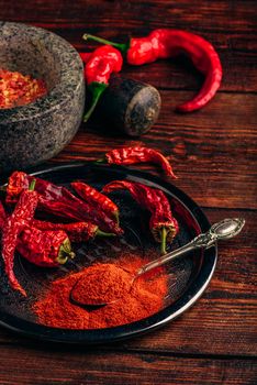 Ground and dried red chili peppers on metal tray