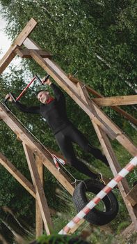 Man passing through hurdles during obstacle course in boot or sport competition