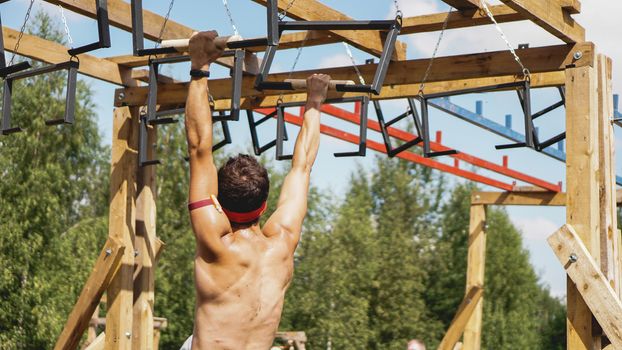 Man passing through hurdles during obstacle course in boot or sport competition