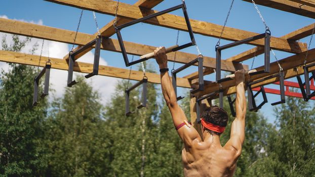 Man passing through hurdles during obstacle course in boot or sport competition