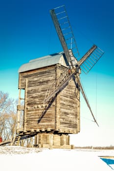 Old wooden windmill close up in winter.