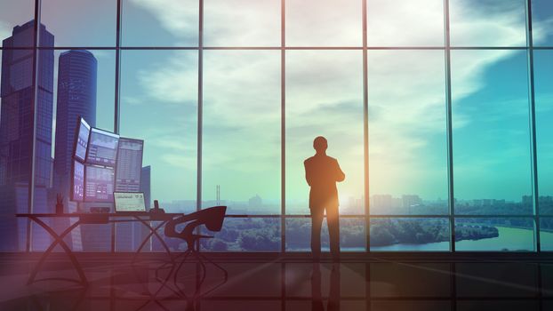 In an office with large windows, there is a silhouette of a trader looking at sunset.