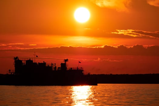 Sunset on the embankment of the Amur river in Khabarovsk. The sun set over the horizon. The embankment is lit by lanterns.