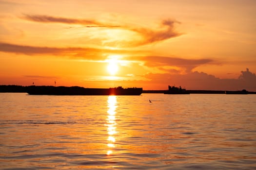 Sunset on the embankment of the Amur river in Khabarovsk. The sun set over the horizon. The embankment is lit by lanterns.