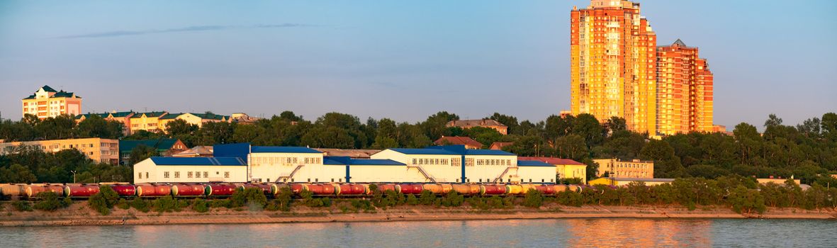 View of the city of Khabarovsk from the Amur river. Urban landscape in the evening at sunset