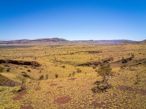 Aerial image of Karijini National Park close to Mount Bruce yellow grass red dust