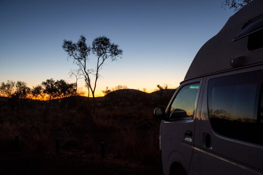 Camper Van at Dales campground facing towards sunset at Karijini National Park Australia