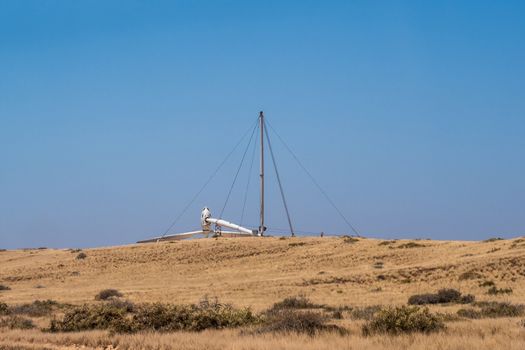 Erectable wind turbine lying flat on ground installed to desalinate salt water
