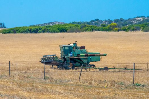 Old combine harvester parked on dry corn field in the western of Australia