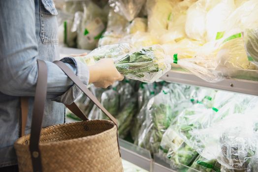 Lady is shopping fresh vegetable in supermarket store - woman in fresh market lifestyle concept