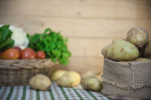 Fresh potato ready for cooking with potato sack background - potato cooking concept