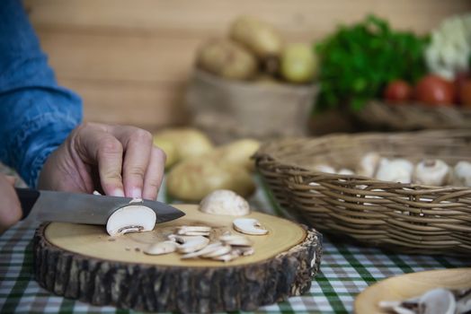 Lady cooks fresh champignon mushroom vegetable in the kitchen - people with vegetable cooking concept