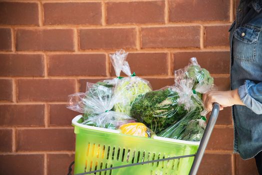 Lady is shopping fresh vegetable in supermarket store - woman in fresh market lifestyle concept